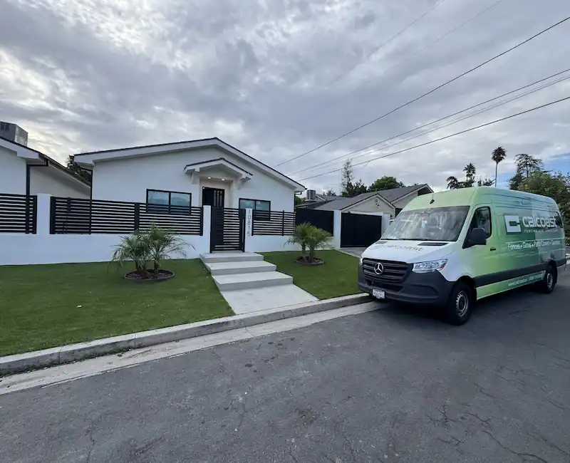 A modern white vinyl fence with a backyard in California