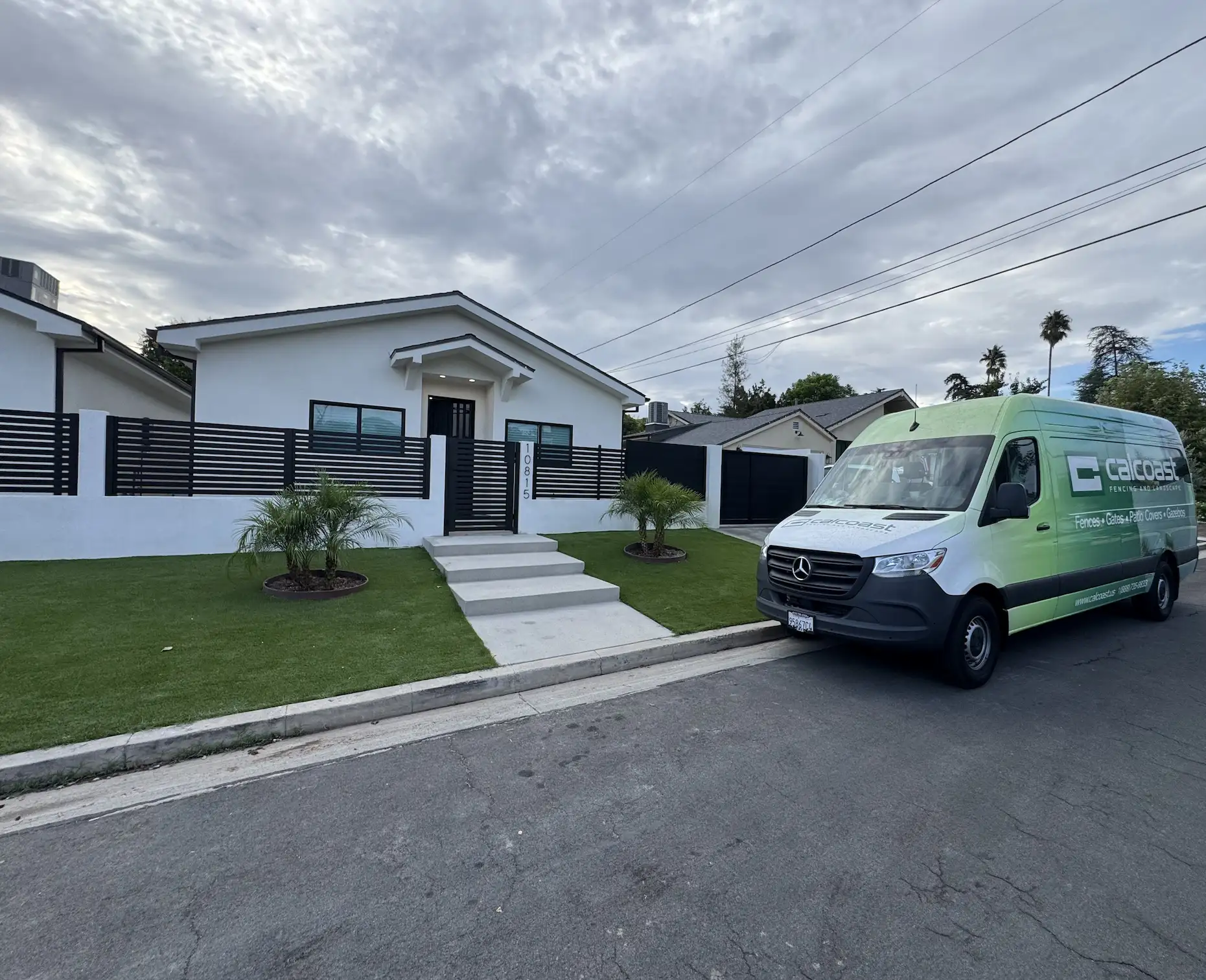 A modern white vinyl fence with a backyard in California